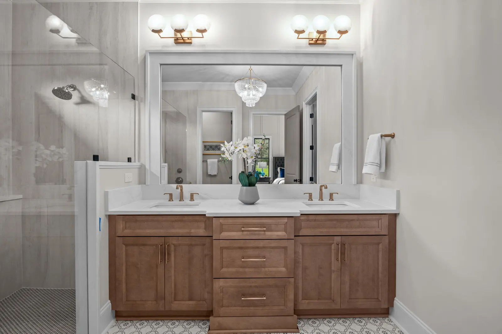 Double vanity in stained wood with brushed brass pulls and faucets